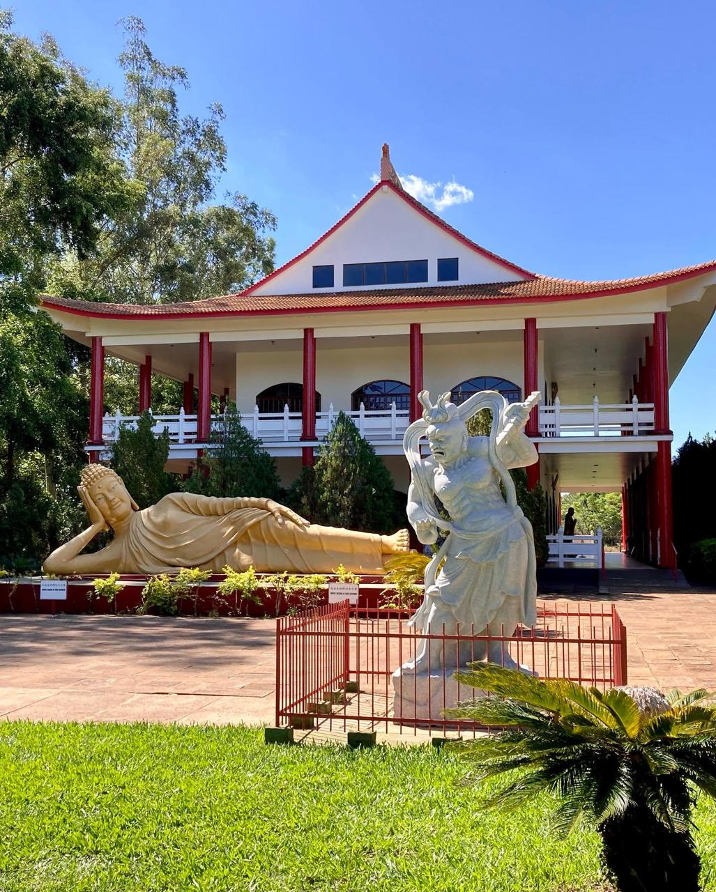 Templo Budista com Buda reclinado e escultura no jardim